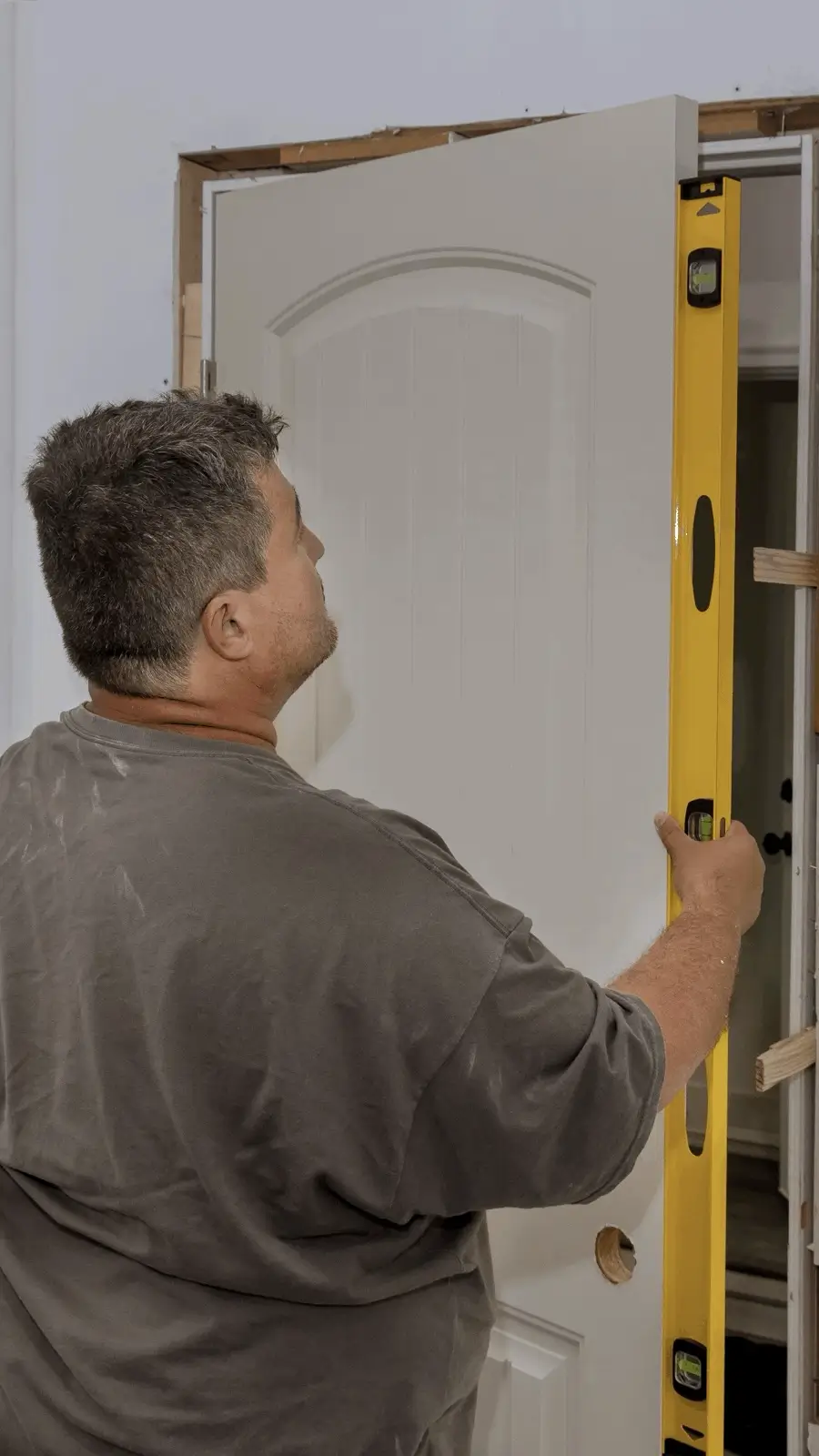 Un homme qui vérifie si la porte est de niveau.